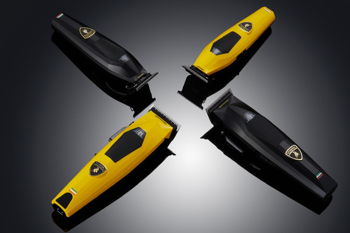 Four hair trimmers in black and yellow on a reflective surface with a dark background