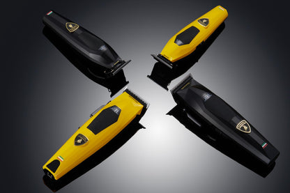 Four hair trimmers in black and yellow on a reflective surface with a dark background