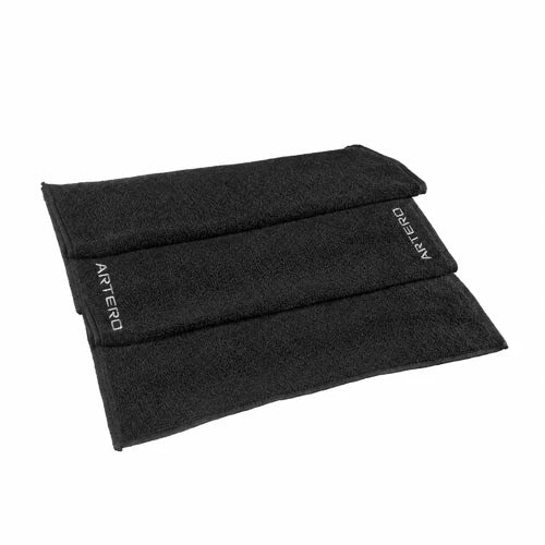 Folded black ARTERO A477 cotton towel with white embroidered ARTERO lettering on a white background